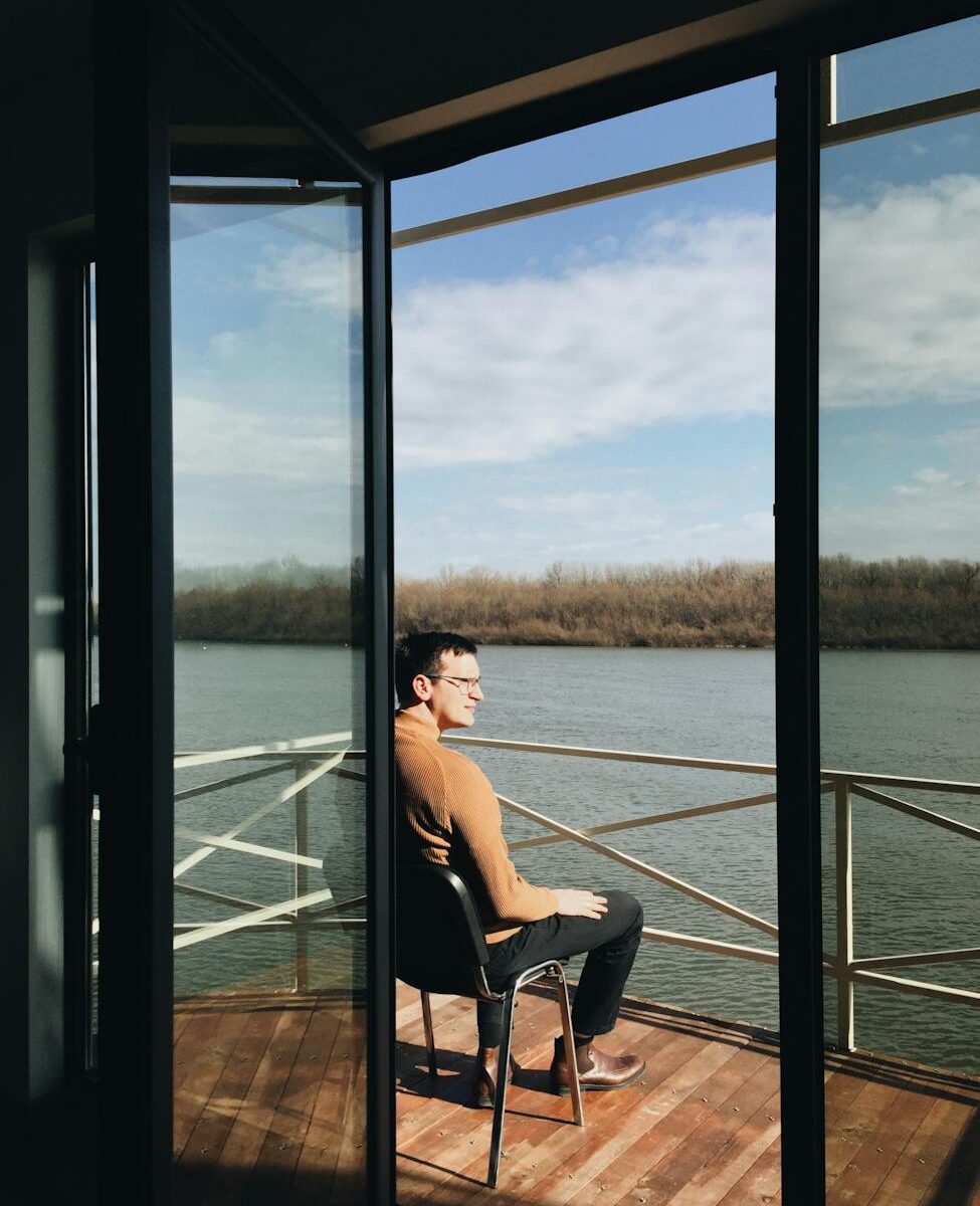 man in sweater sitting by rail