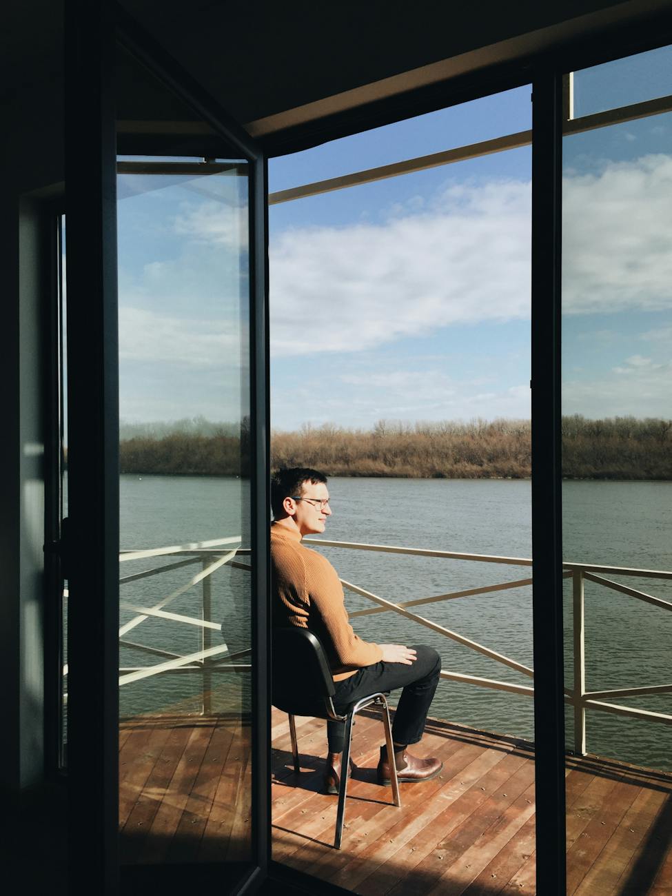 man in sweater sitting by rail